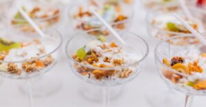 Close-up image of yogurt parfaits with granola and fruit served in elegant glassware for breakfast.